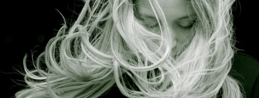 Junge Frau mit blonden langen Haaren im Wind - Der beste Friseur